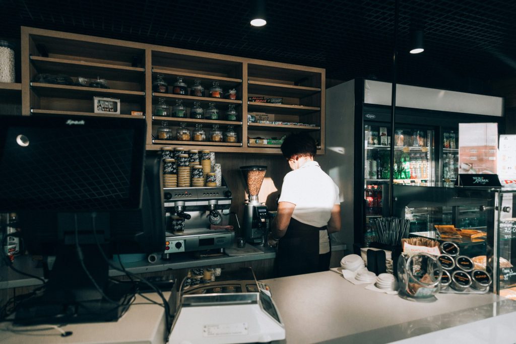woman wearing white top behind counter